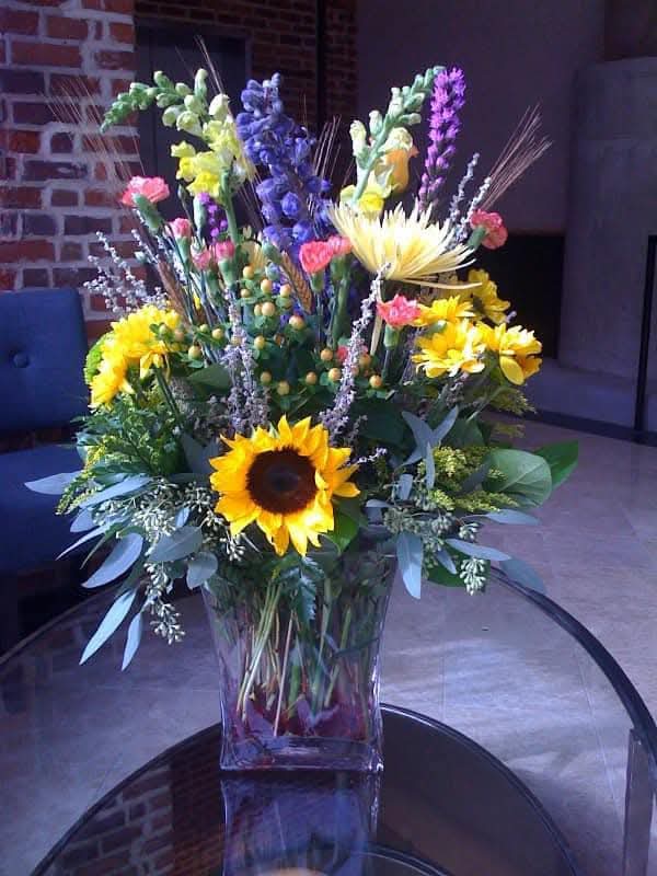 Mixed seasonal bouquet with sunflowers, delphinium, and snapdragons